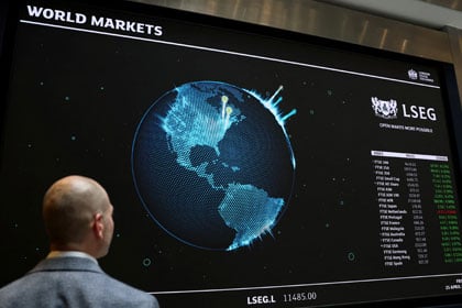 person looking at world markets on a large screen