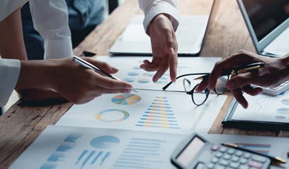 Professionals analyzing financial data and charts on a desk